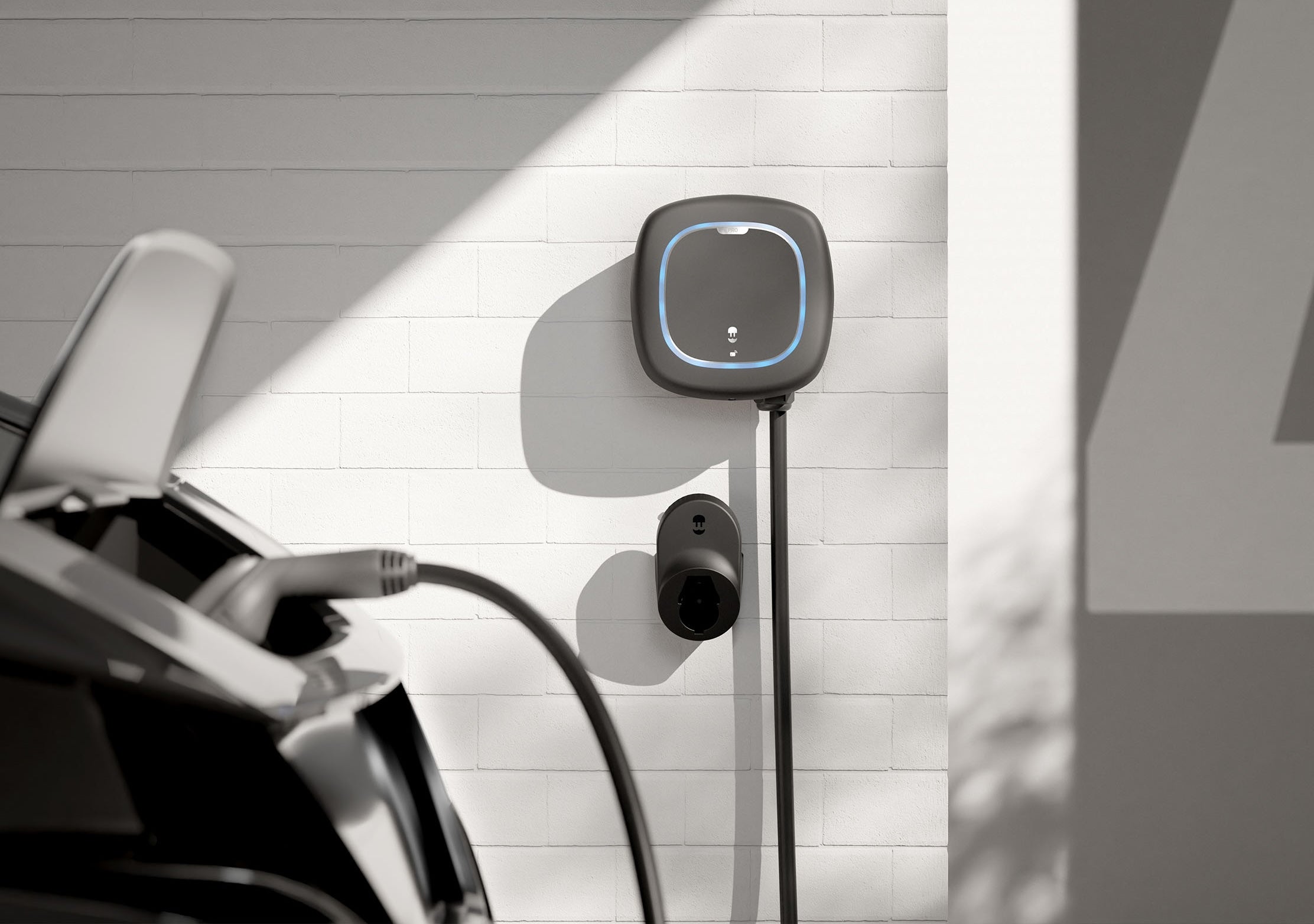 Επιτοίχιος φορτιστής Wallbox Pulsar Pro με ενσωματωμένο καλώδιο Type 2 φορτίζει ηλεκτρικό αυτοκίνητο σε οικιακό χώρο στάθμευσης.