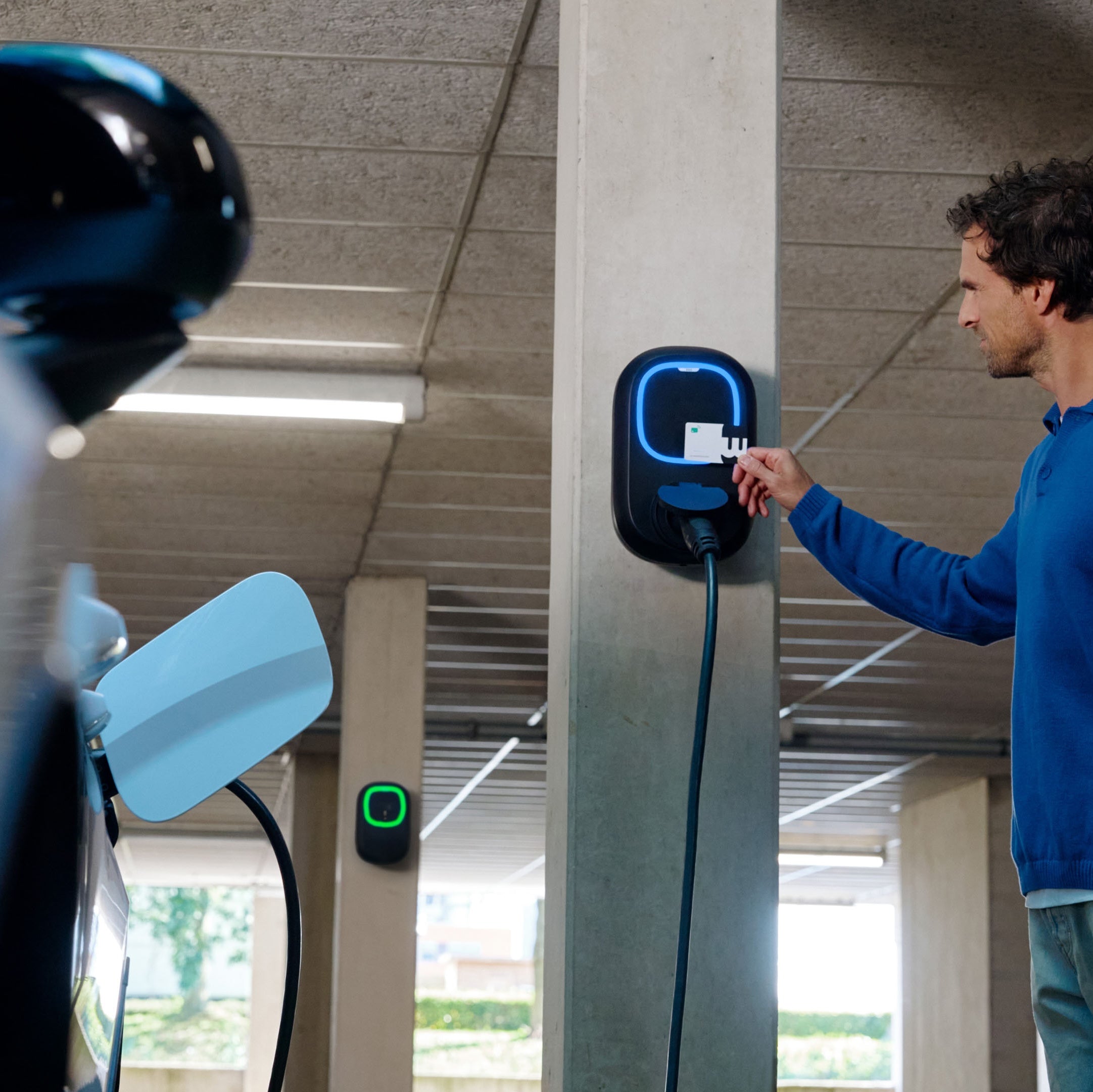 Άνδρας φορτίζει με κάρτα RFID σε επιτοίχιο φορτιστή Wallbox Pulsar Pro με υποδοχή Type 2.